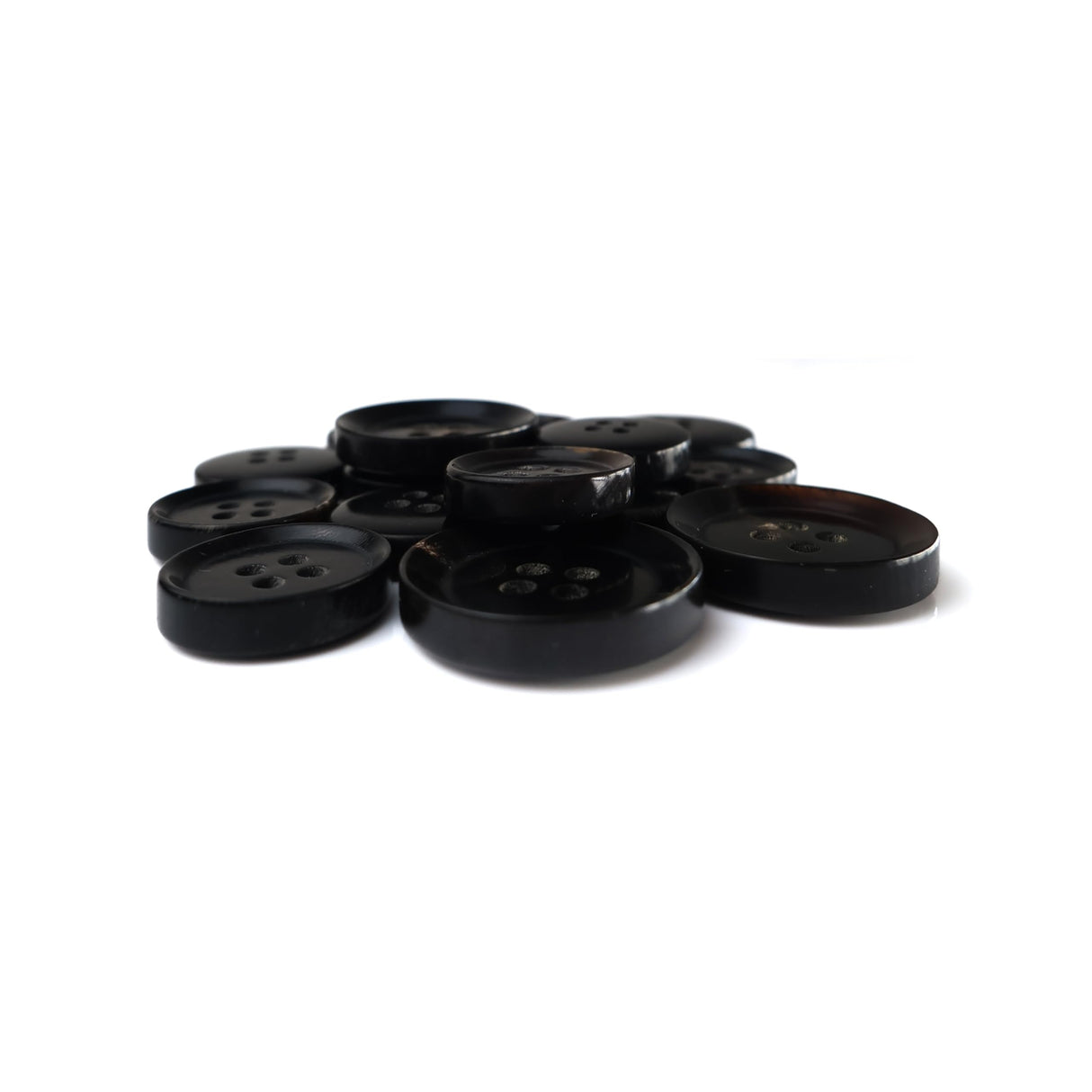 Buffalo Horn Suit Buttons, round and black with four holes, are shown in a pile on a white background.