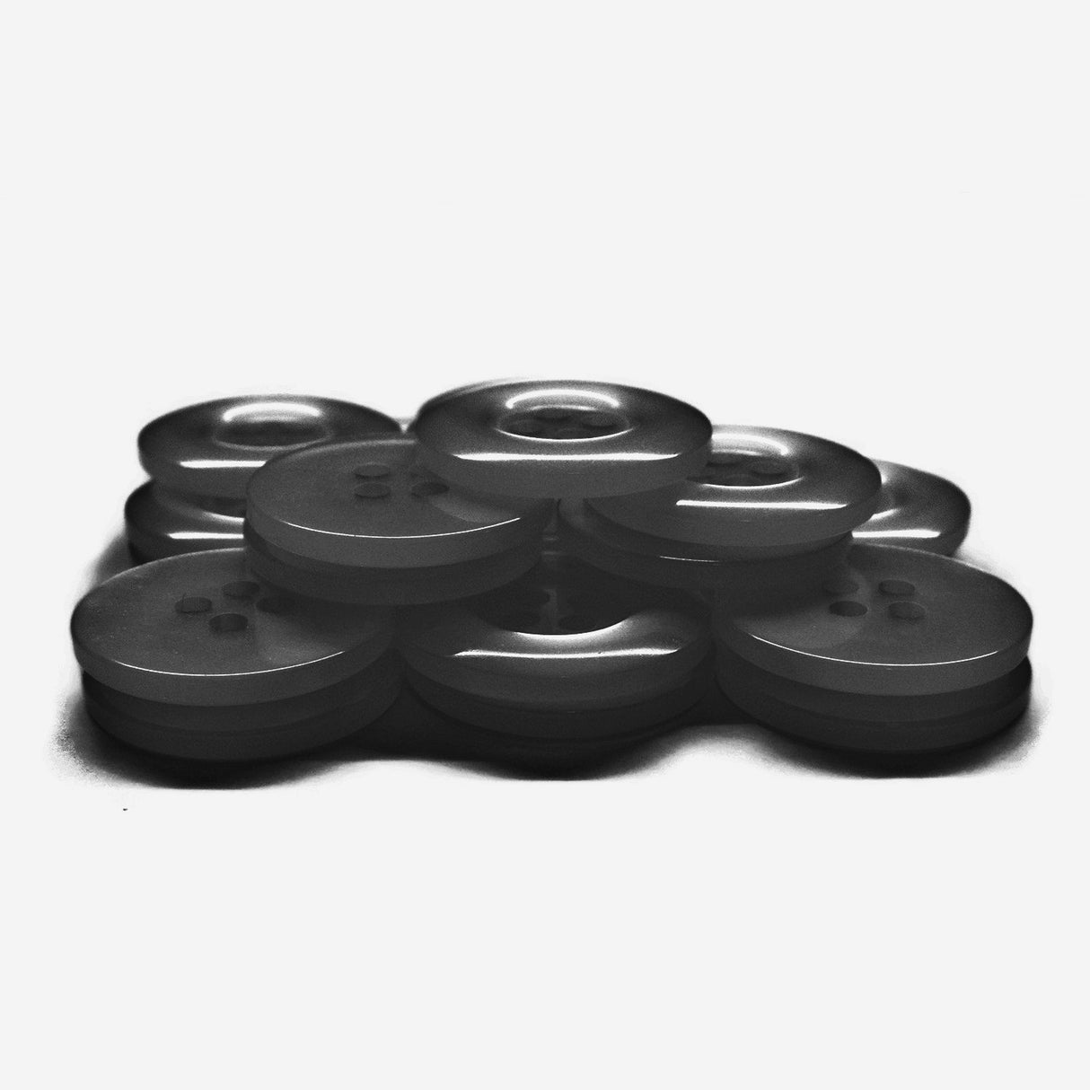 A cluster of Commercial Food Service Buttons made from black nylon, arranged on a white background.