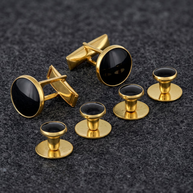 Tuxedo Shirt Studs and Cufflinks, ideal tuxedo shirt accessories in gold and black, are elegantly arranged on a dark textured surface.