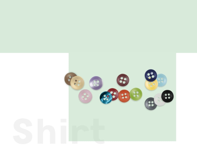 Colorful buttons arranged on a light green and white background with the word "Shirt" faintly visible.