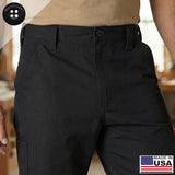 A person is wearing black pants and a beige shirt, with a Made in USA label and flag in the lower right corner. The black pants are equipped with Work Pants Buttons, offering durability and reliability for demanding environments.