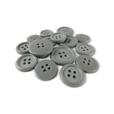 A pile of Basic Suit Buttons—assorted gray poly-nylon blazer buttons with four holes—on a white background.