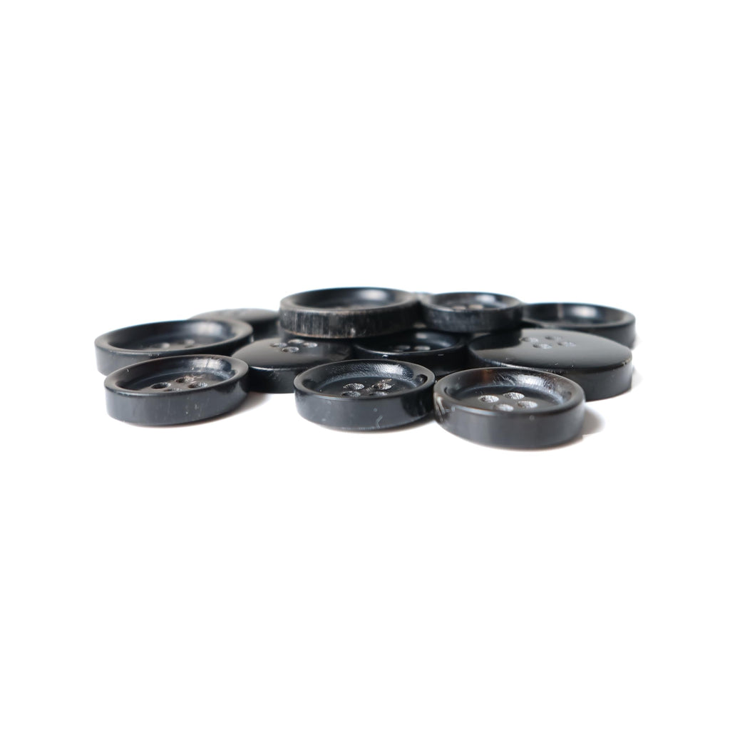 Buffalo Horn Suit Buttons are scattered in a pile on a white background.