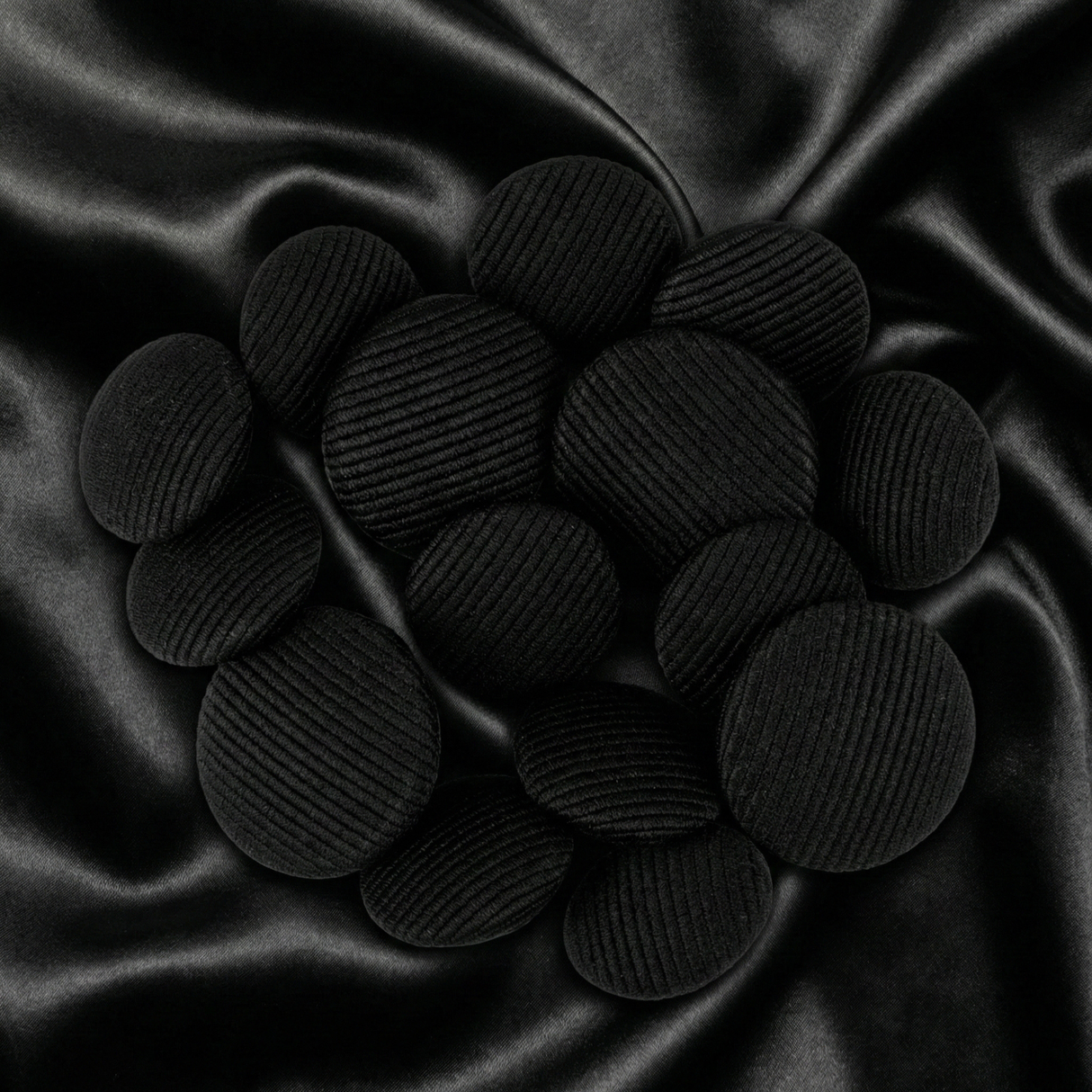 Tuxedo Suit Buttons are displayed in a cluster on smooth, crumpled black satin fabric.