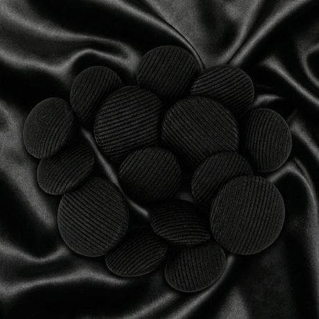 Tuxedo Suit Buttons are displayed in a cluster on smooth, crumpled black satin fabric.