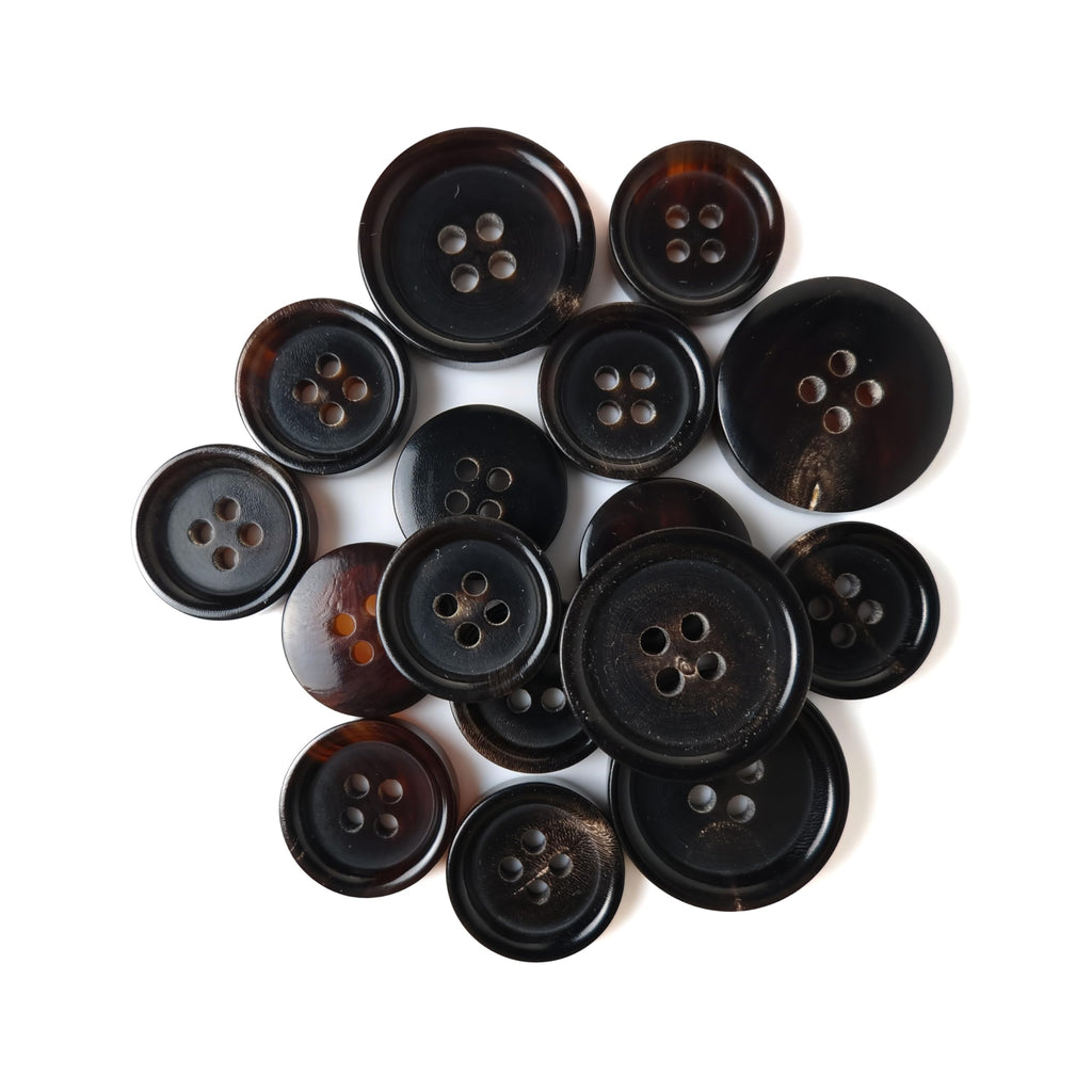 A selection of Buffalo Horn Suit Buttons in different sizes is arranged on a white background.