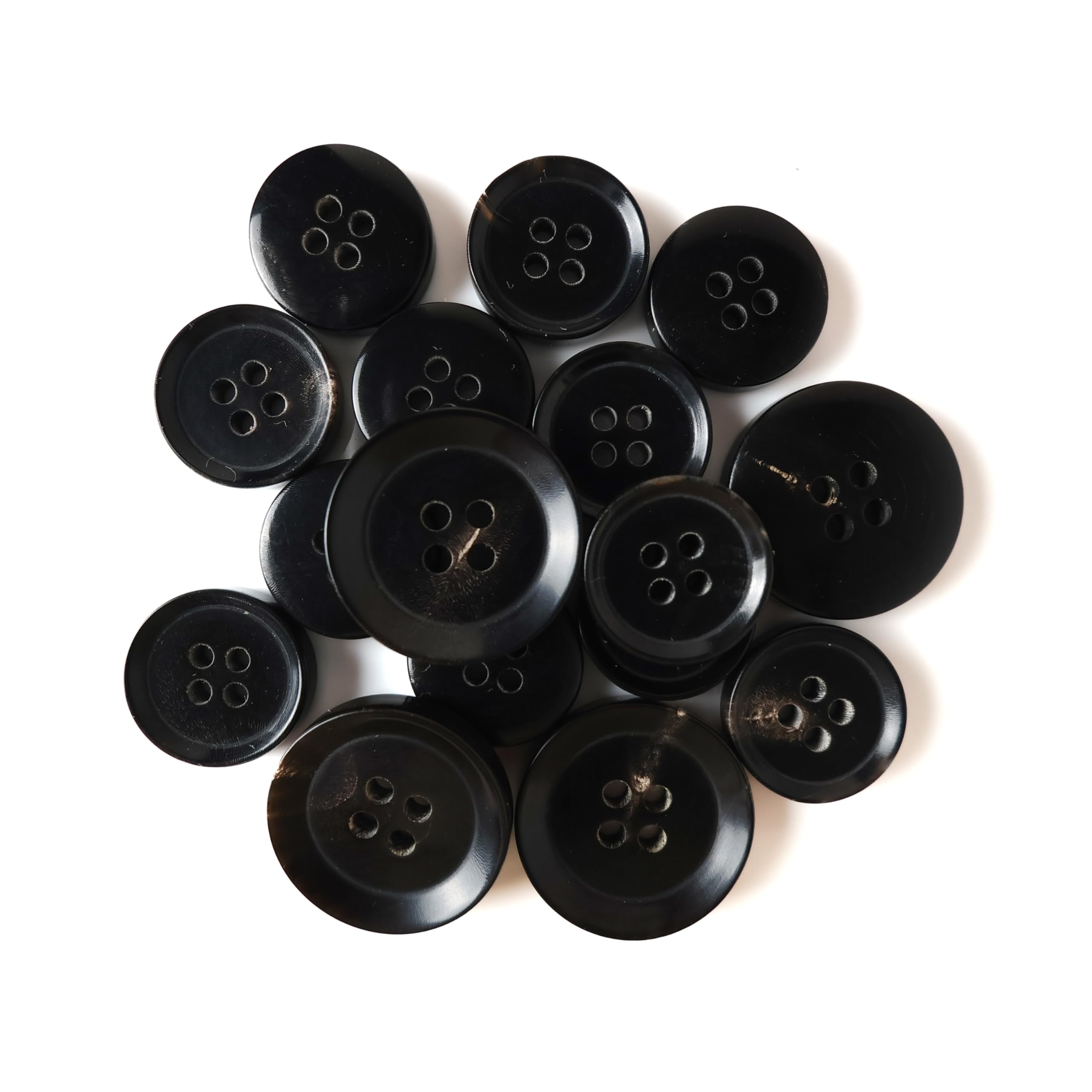 Buffalo Horn Suit Buttons, black and round with four holes, are grouped together on a white background.