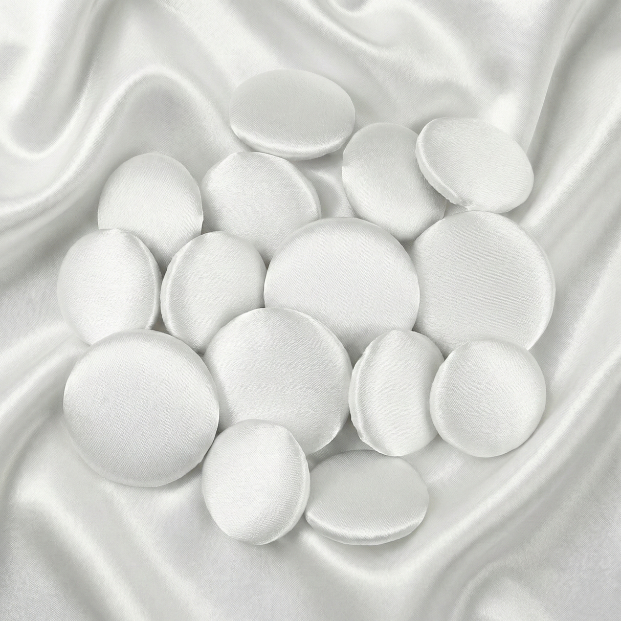 Tuxedo Suit Buttons: Round white satin buttons displayed on smooth, shiny white satin fabric—ideal for accenting formalwear or complementing elegant tuxedo attire.