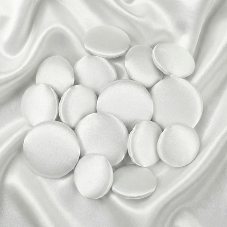 Tuxedo Suit Buttons: Round white satin buttons displayed on smooth, shiny white satin fabric—ideal for accenting formalwear or complementing elegant tuxedo attire.