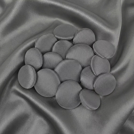 Tuxedo Suit Buttons in round gray velvet are displayed on matching satin fabric, reflecting the refined elegance and classic style of traditional formalwear.