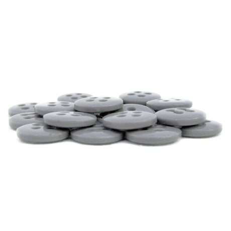 A set of flat, round, gray Trouser Fly Pant Buttons with four holes is displayed on a white background.