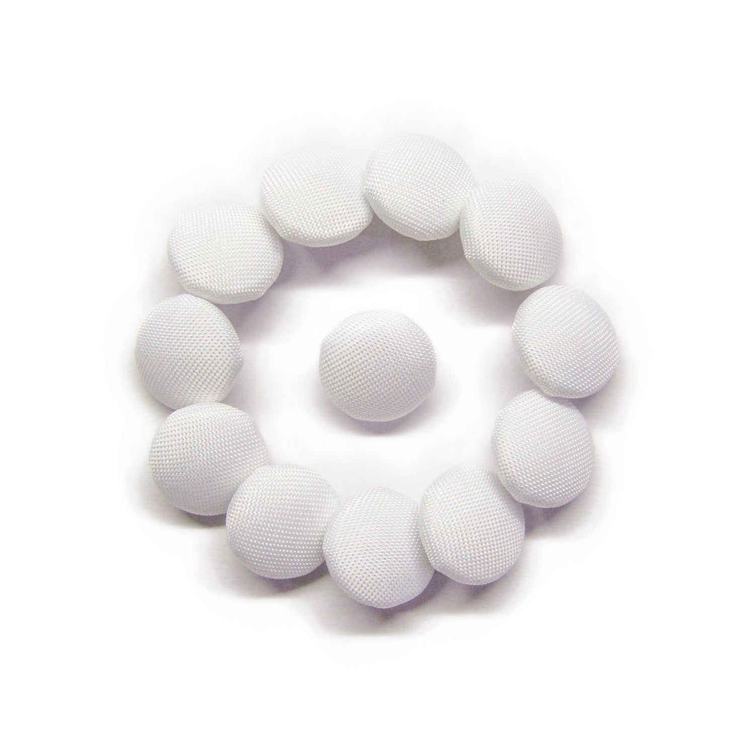 Eleven Taffeta Bridal Buttons are arranged in a circle around one on a white background, evoking the elegant details of a wedding dress.