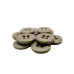 A pile of round, beige Uniform Shirt Buttons with four holes rests on a white background.