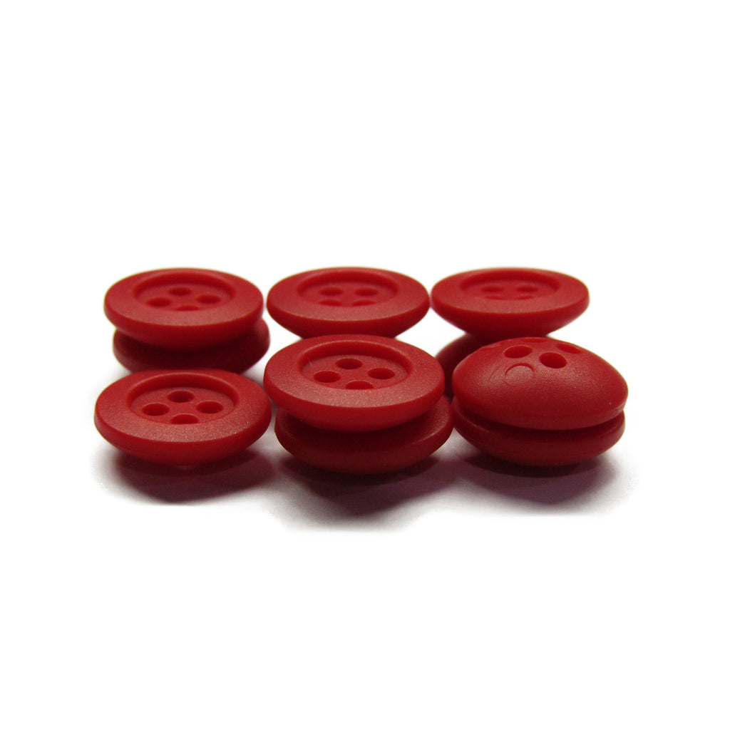 Six Rubber Shirt Buttons—red, round, each with four holes—arranged on a white background, ideal for children's clothing.