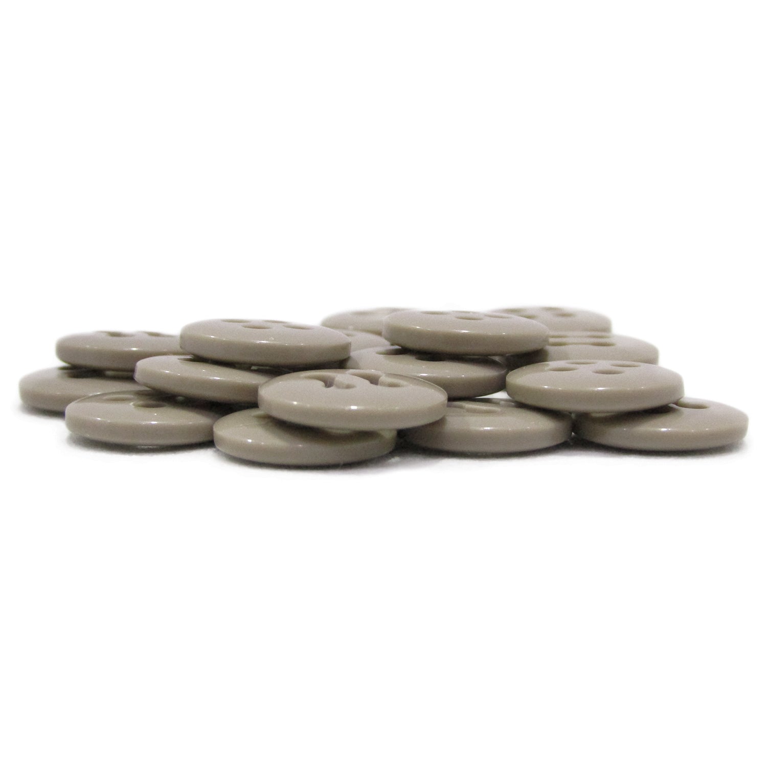 A stack of flat, round, light brown Trouser Fly Pant Buttons arranged on a white surface.