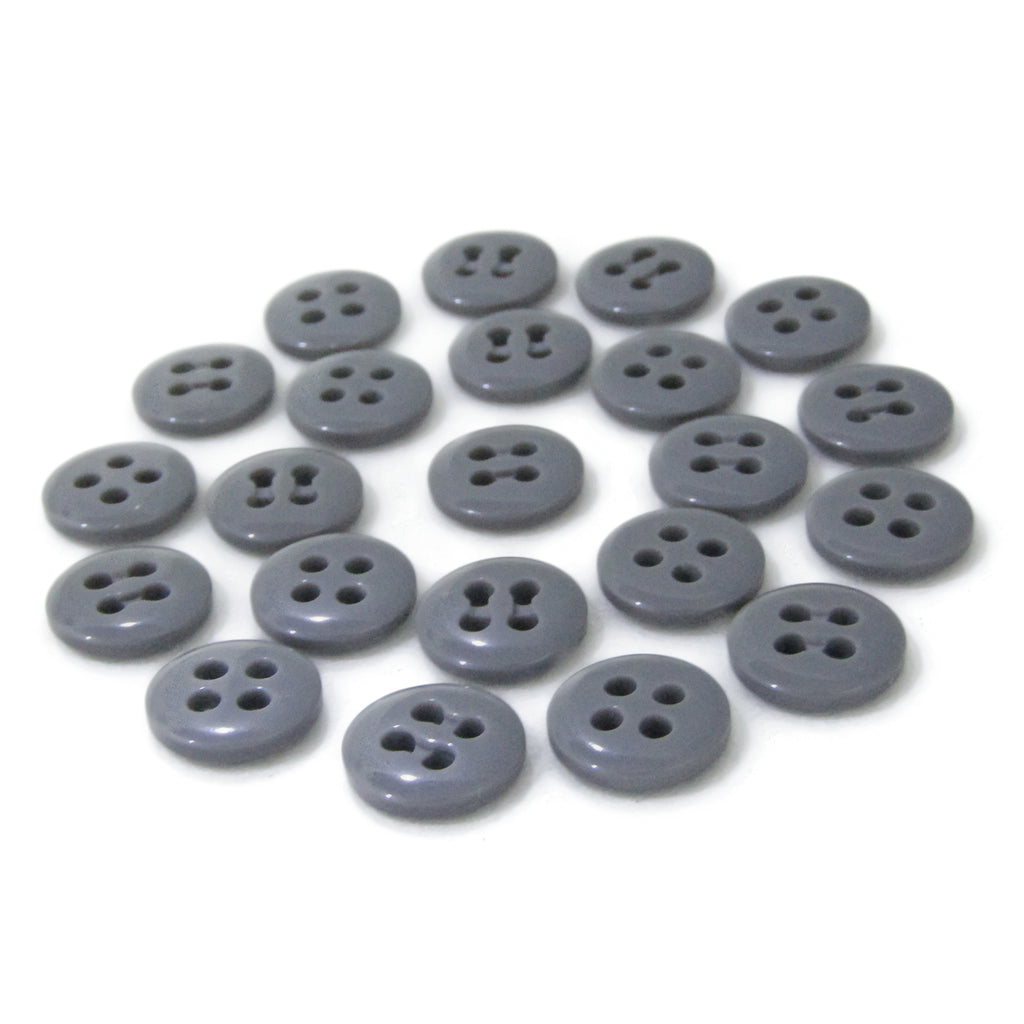 A collection of scattered gray Trouser Fly Pant Buttons, featuring two- and four-hole designs, displayed on a white background.