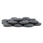 A stack of round, flat, black Trouser Fly Pant Buttons with four holes is arranged on a white surface.