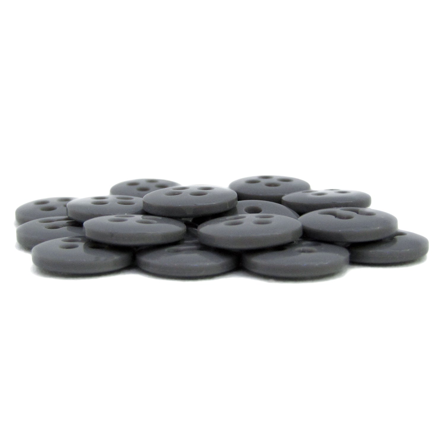 A stack of round, flat, black Trouser Fly Pant Buttons with four holes is arranged on a white surface.