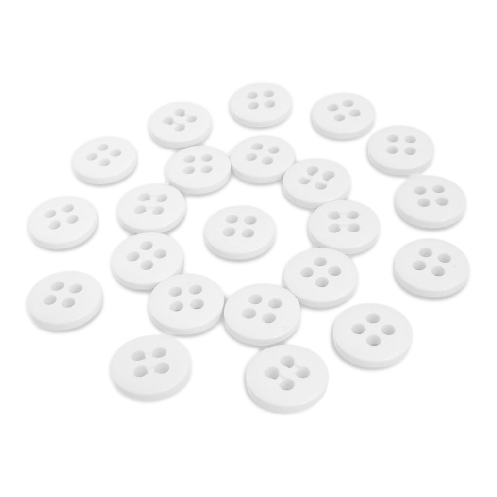A collection of white, round Trouser Fly Pant Buttons with four holes is scattered on a white surface.