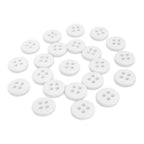A collection of white, round Trouser Fly Pant Buttons with four holes is scattered on a white surface.