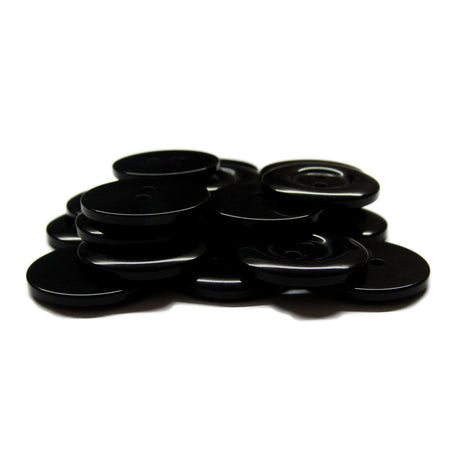 A pile of Commercial Food Service Buttons, black and round on a white background—ideal replacements for work uniform buttons.