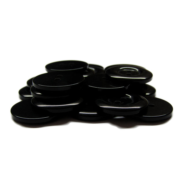 A pile of Commercial Food Service Buttons, black and round on a white background—ideal replacements for work uniform buttons.