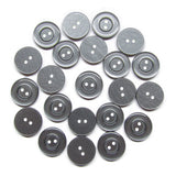 Twenty-five Commercial Food Service Buttons, round and gray with two holes, are arranged in a loose circular pattern on a white background.