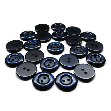 A collection of dark blue and black round Commercial Food Service Buttons with two holes, scattered on a white surface.
