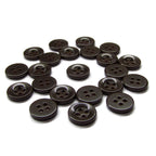 A set of black, four-hole Workshop Uniform Shirt Buttons made from durable nylon, displayed on a white surface.