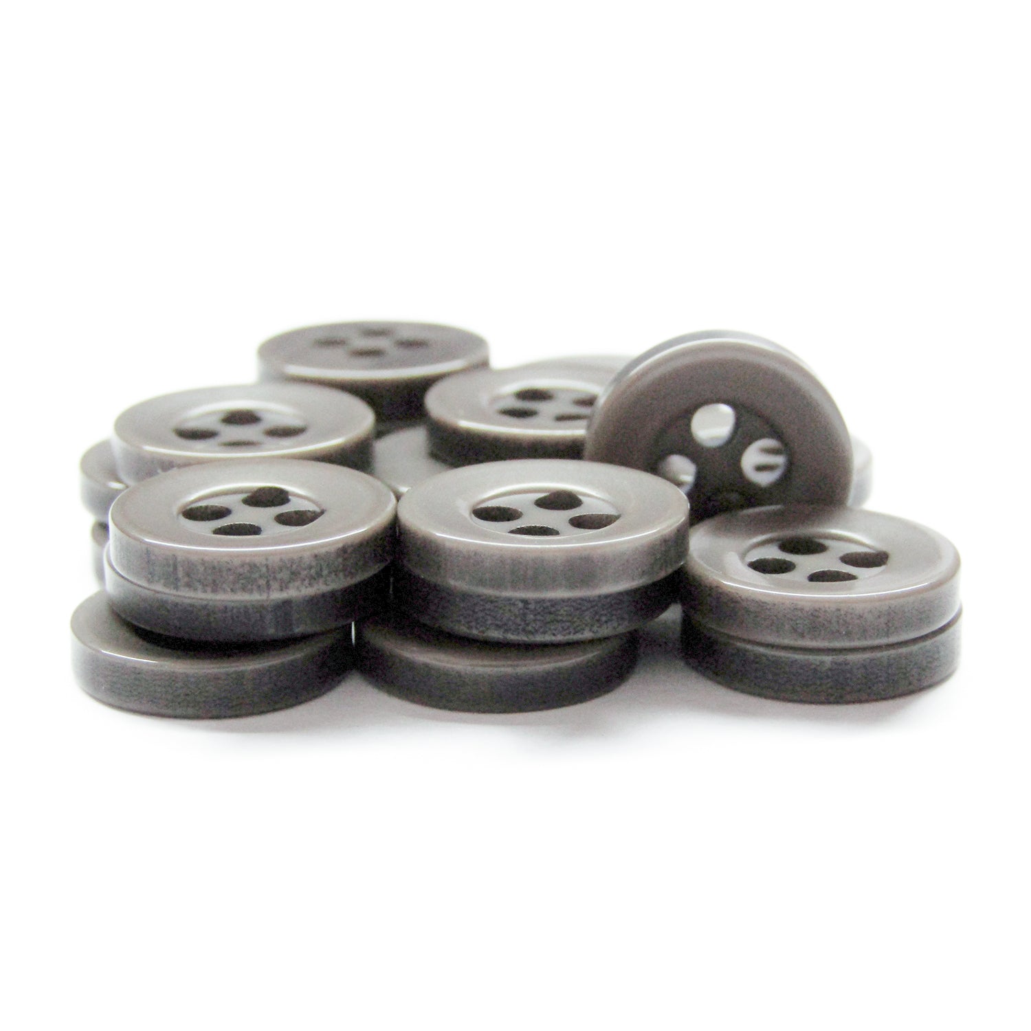 A stack of dark gray, round Workshop Uniform Shirt Buttons made of durable nylon with four holes arranged on a white background.