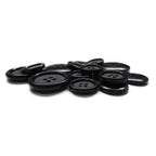 A pile of black Vegan Faux Horn Suit Buttons with four holes in various sizes on a white background.
