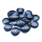 A pile of Luxury Suit Buttons, dark blue with four holes and made of vegan plastic, sits on a white background.