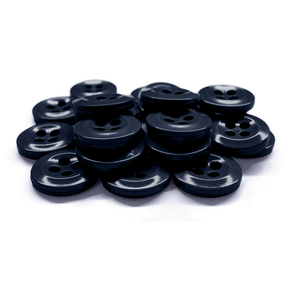 A pile of black, four-hole plastic Work Shirt Buttons 22 Pack on a white surface—ideal as durable replacements for military spec or industrial work shirts.
