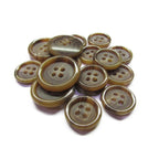 A pile of Luxury Suit Buttons in brown, four-hole, vegan design and various sizes on a white background.