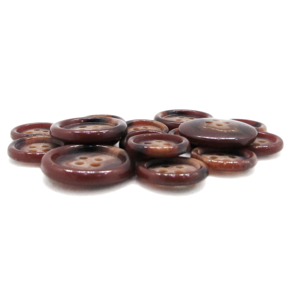 A pile of Luxury Suit Buttons, featuring assorted brown round four-hole styles, is spread on a white surface.