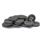 A stack of gray, round Workshop Uniform Shirt Buttons with four holes displayed on a white background.