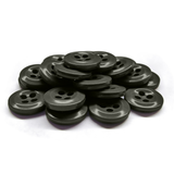 A stack of black, round, four-hole Work Shirt Buttons lies on a white surface.