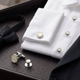 A white dress shirt accented with the Tuxedo Shirt Studs and Cufflinks, a black bow tie, and a dark suit jacket on a leather surface—an elegant ensemble elevated by these sophisticated tuxedo shirt accessories.
