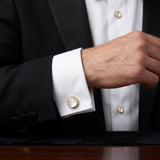 A man in a tuxedo displays the Tuxedo Shirt Studs and Cufflinks in gold and white stainless steel on his white dress shirt, emphasizing the sophistication of these essential accessories.
