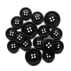 Premium Suit Buttons—round, black, four-hole, and available in various sizes—are neatly arranged on a white background.
