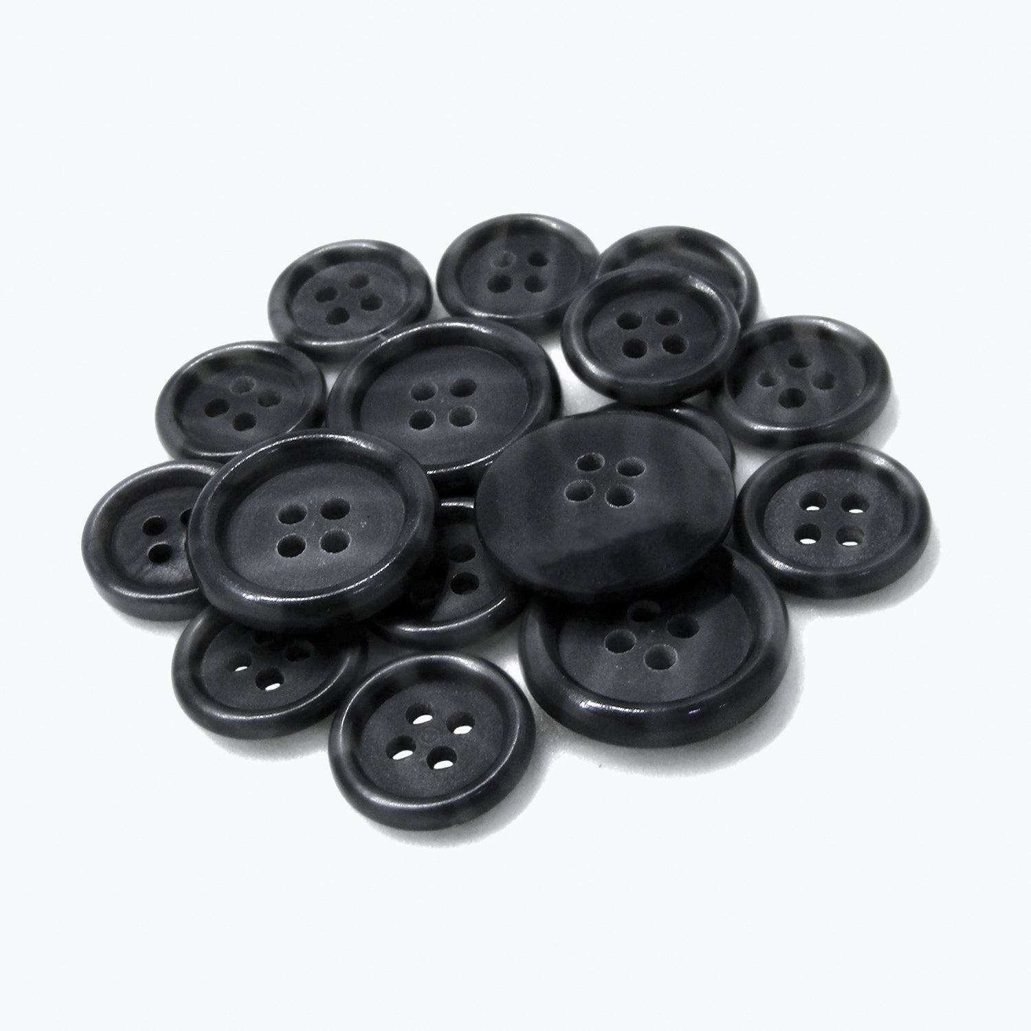 A pile of Luxury Suit Buttons, black, round with four holes, displayed on a plain white background.