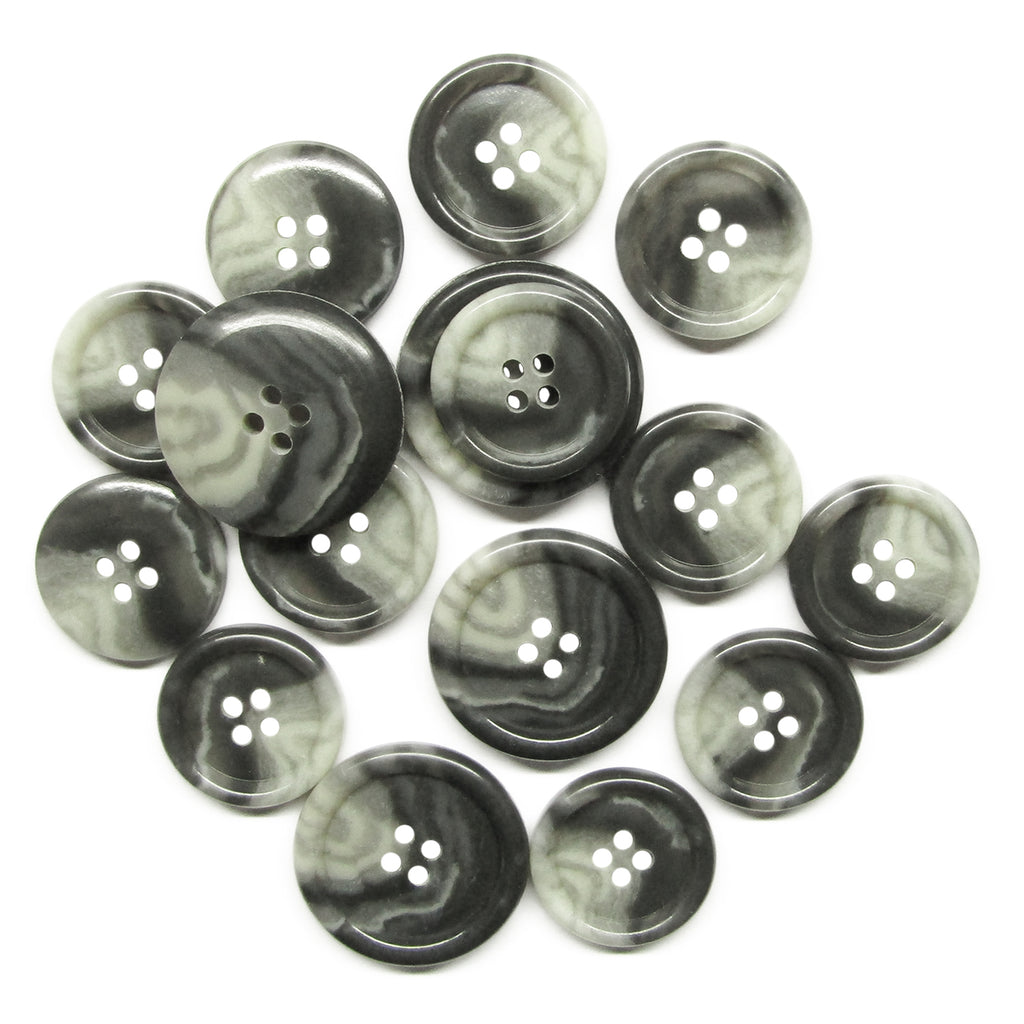 Premium Suit Buttons, featuring a black and white marbled design and four holes each, are scattered on a white surface.