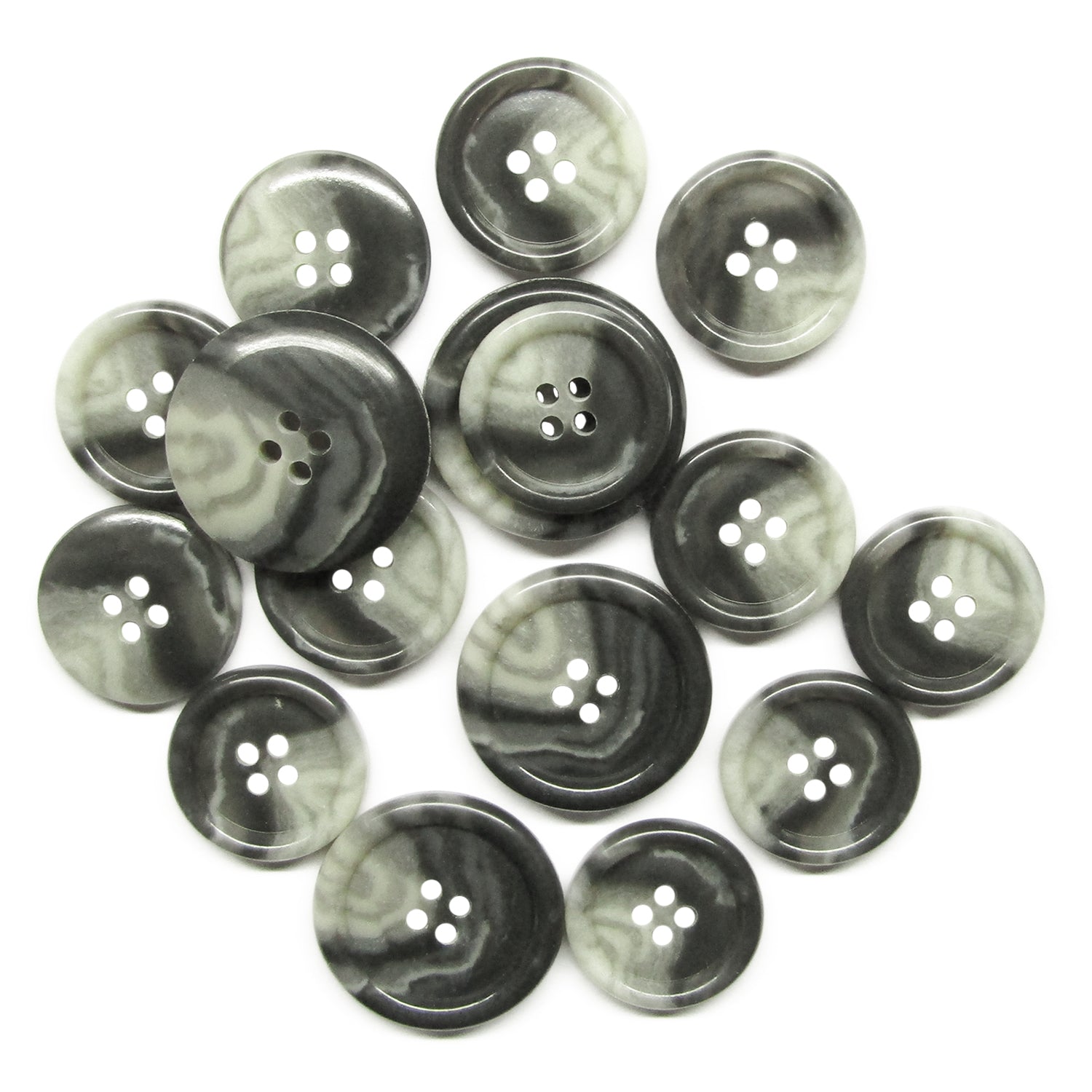 Premium Suit Buttons, featuring a black and white marbled design and four holes each, are scattered on a white surface.