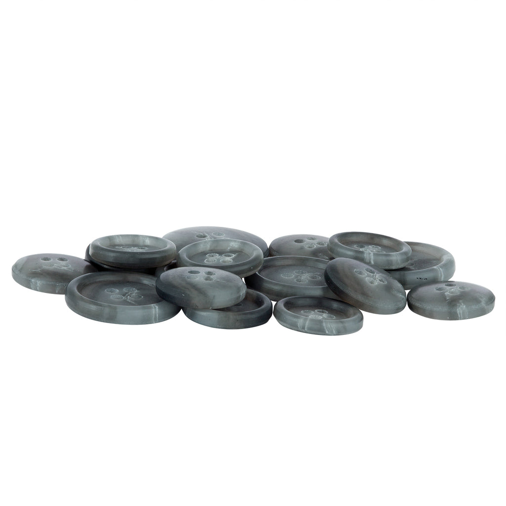 A collection of Vegan Faux Horn Suit Buttons, round and gray with four holes, scattered on a white surface.