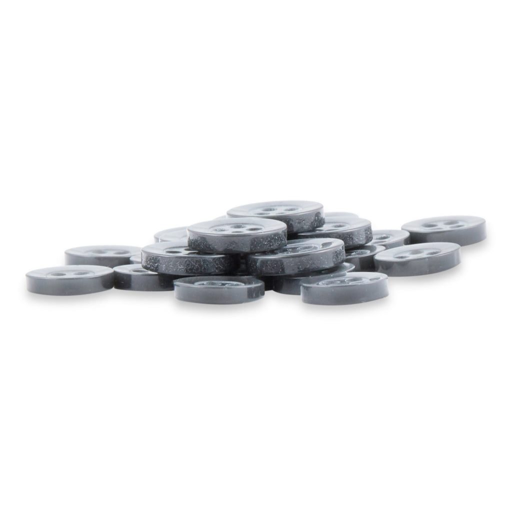A stack of Replacement Shirt Buttons—small, round, flat gray poly-nylon buttons with a matte finish and four holes each—lies on a white surface.