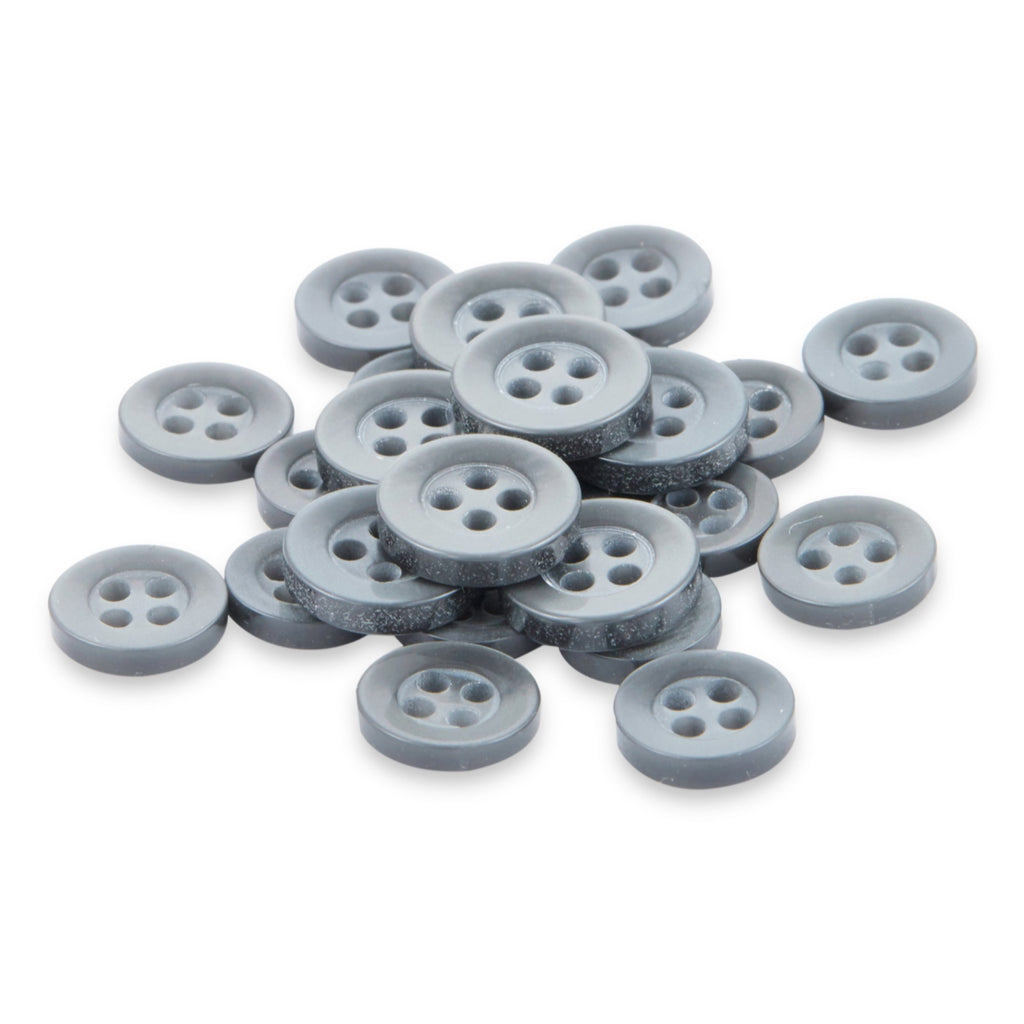 A collection of small, round, gray matte Replacement Shirt Buttons is scattered across a white surface.