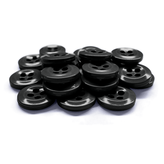 Work Shirt Buttons in black are scattered and stacked on a white surface.