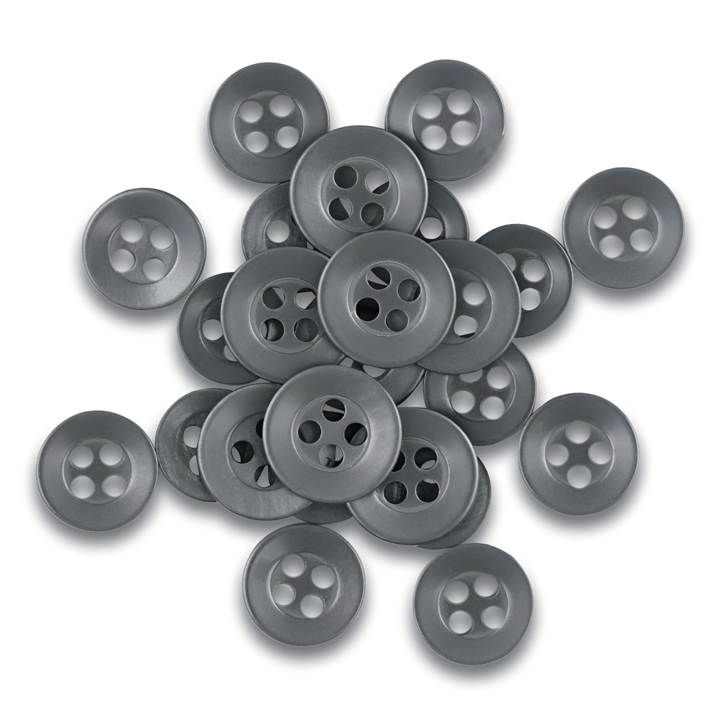 A pile of round, gray Replacement Shirt Buttons, valued for their durability, scattered on a white background—ideal for any tailor's kit.