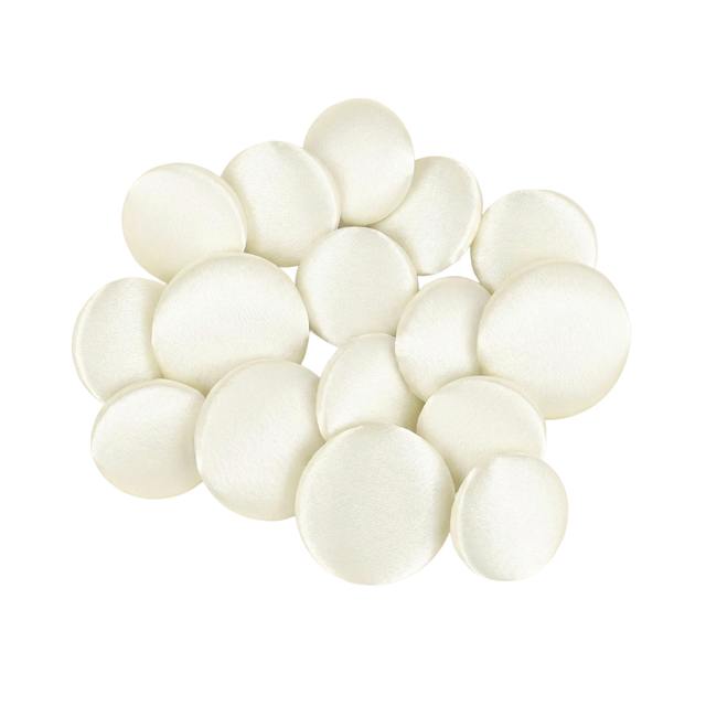 A pile of Tuxedo Suit Buttons made from round, smooth, white satin fabric rests on a white background.