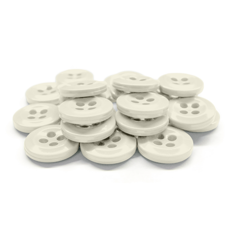A stack of white Work Shirt Buttons with four holes arranged on a white background.